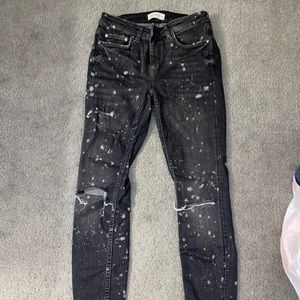 Black mid-rise skinny jeans with paint splatter
